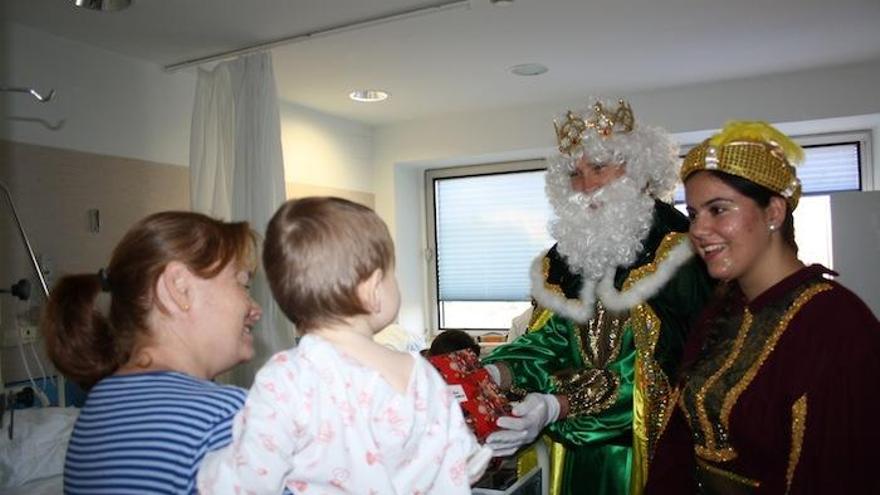 El rey Melchor entrega un regalo a un niño en el Materno Infantil.