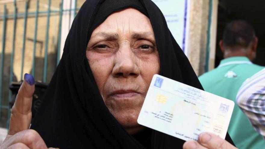 Una mujer muestra su dedo marcado tras votar.