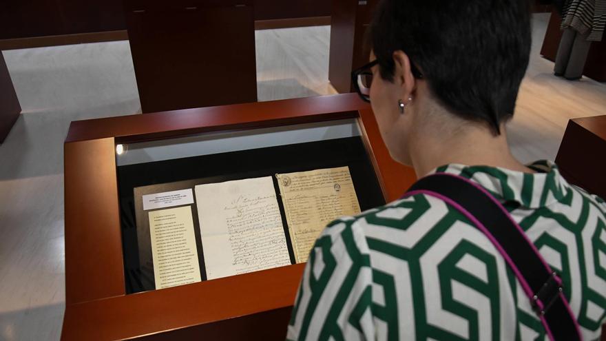 Una mujer contempla unos de los documentos exhibidos en la muestra del Archivo Histórico Provincial.