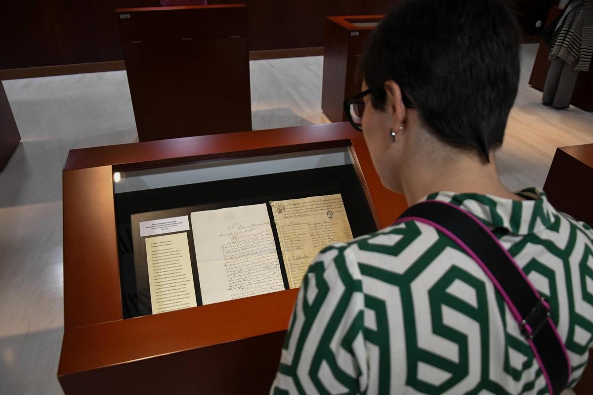 Una mujer contempla unos de los documentos exhibidos en la muestra del Archivo Histórico Provincial.