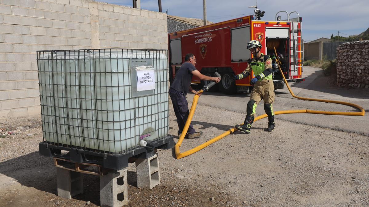 Un bombero de la DPZ rellena un depósito de agua en una calle de Villafranca de Ebro.