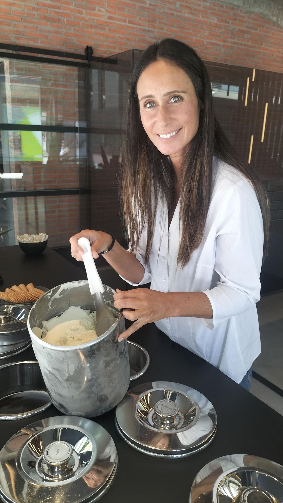 La encargada de la tienda en Cangas, con la cubeta de helado y la paleta para servirlo.