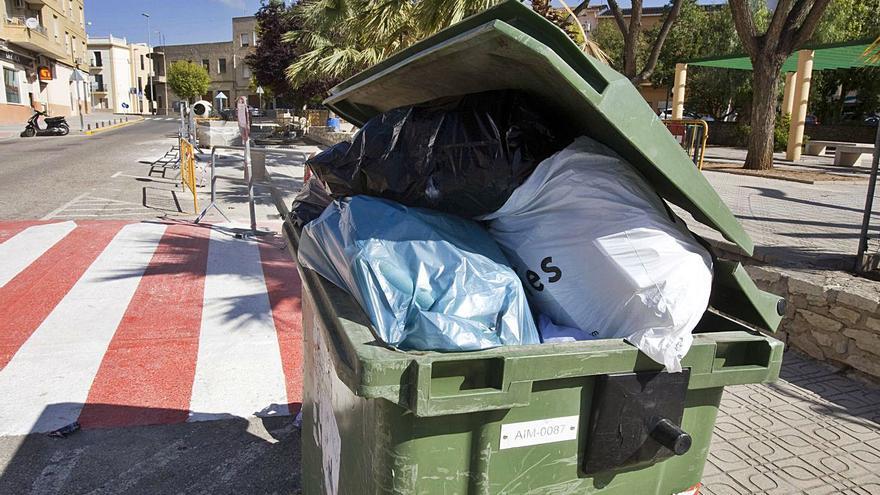 Un contenedor de basura repleto, en una calle de Aielo, en una imagen de archivo. | PERALES IBORRA