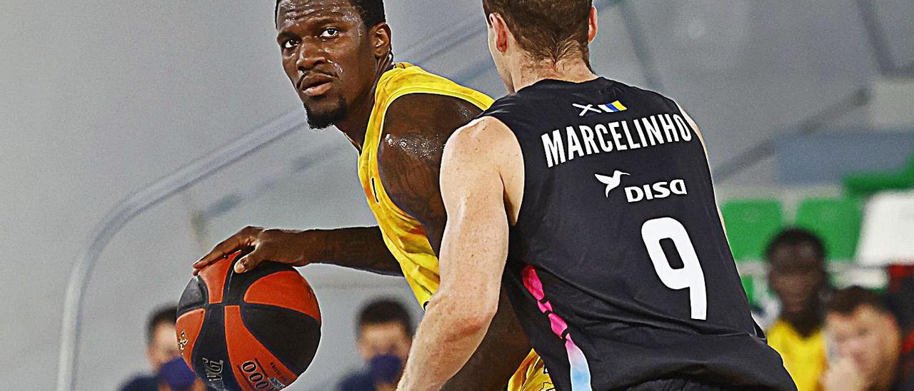 Dylan Ennis bota el balón ante la presión del base del Lenovo Tenerife, Marcelinho Huertas, el pasado jueves. | | EMILIO COBOS