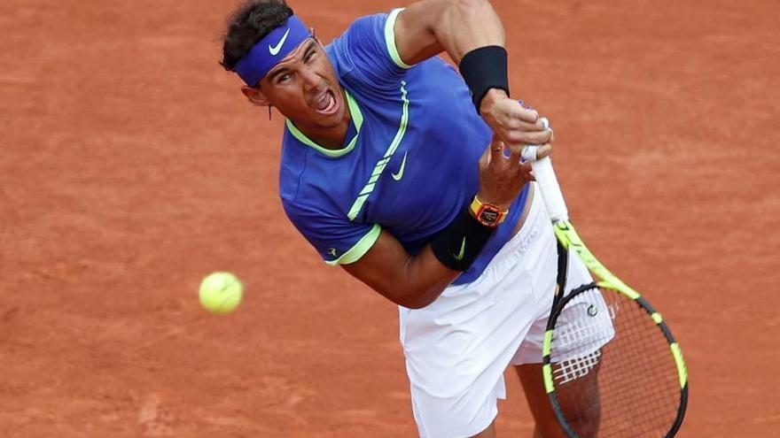Rafel Nadal aparece tras golpear la bola en su primer partido de Roland Garros, disputado ayer ante el francés Benoît Paire.