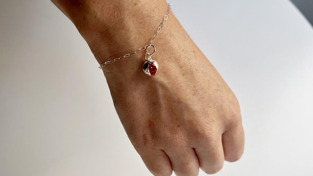 Detalla de la pulsera con la granada de cristales Swarovski que regalará la DOP a las fruterías.