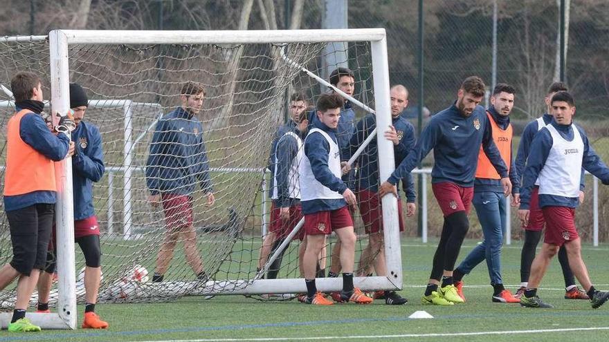 Parte de la plantilla moviendo una portería en un entrenamiento en A Xunqueira.  // Rafa Vázquez