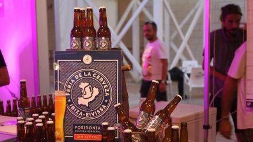 Varios botellines de cerveza junto a un cartel promocional de la VIII edición de la Feria.