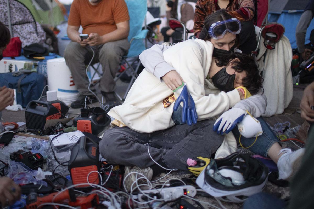Pro-Palestinian demonstrators embrace while charging devices at an encampment on the UCLA campus Wednesday, May 1, 2024, in Los Angeles. (AP Photo/Ethan Swope) Associated Press/LaPresse / EDITORIAL USE ONLY/ONLY ITALY AND SPAIN