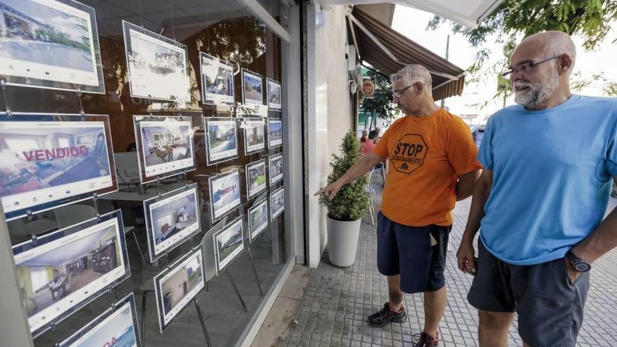 Fernando López, en primer término, y Sergi Aleixandre miran el escaparate de una inmobiliaria de Palma.