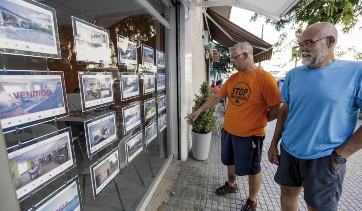 Fernando López, en primer término, y Sergi Aleixandre miran el escaparate de una inmobiliaria de Palma.