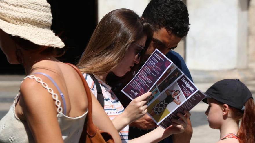 Imatge d&#039;un grup de turistes mirant un fulletó al mig de la plaça Sant Jaume.