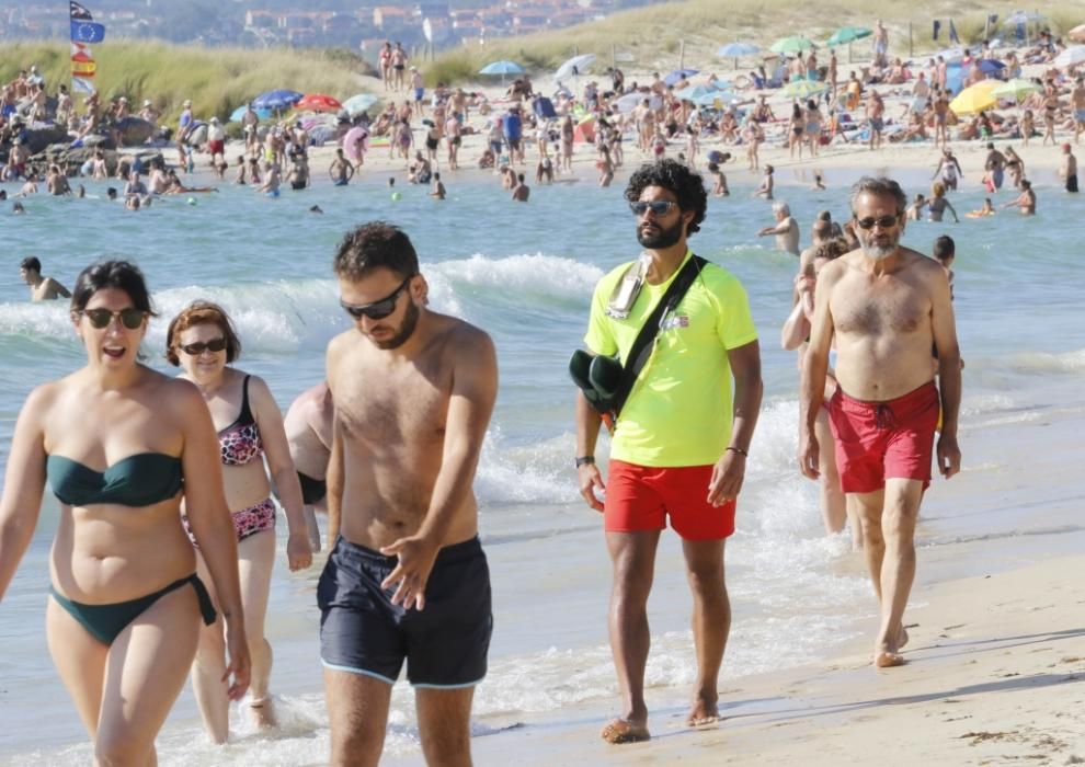 El buen tiempo anima a los bañistas en la playa de Samil