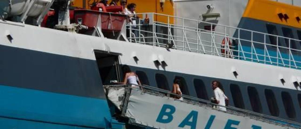 Pasajeros de un buque de Baleària accediendo a bordo del barco en el puerto de Dénia, en una imagen de archivo.
