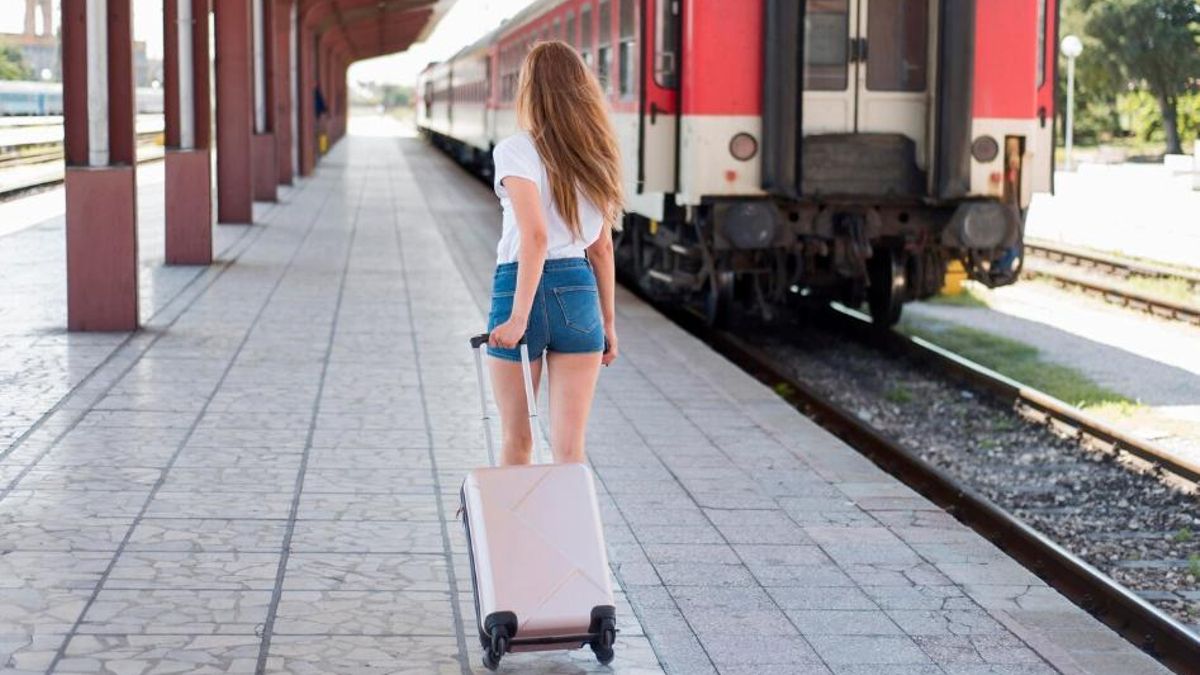 Una joven accede con su equipaje al tren