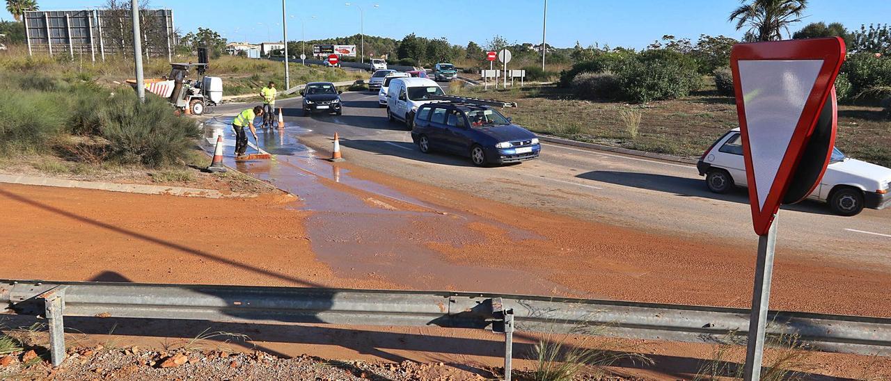 Dos operarios limpian el barro provocado por una fuga de agua junto a la rotonda de Can Negre, en una imagen de archivo.