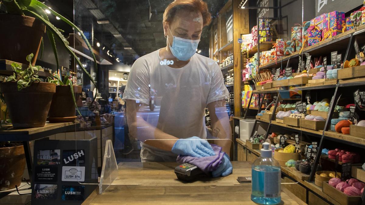 Un trabajador de un comercio de València durante la pandemia.