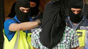Police lead away a suspect from an apartment block during a raid in which they arrested a 32-year-old Moroccan they said was highly radicalised, in Madrid, Spain June 21, 2017.  REUTERS/Juan Medina