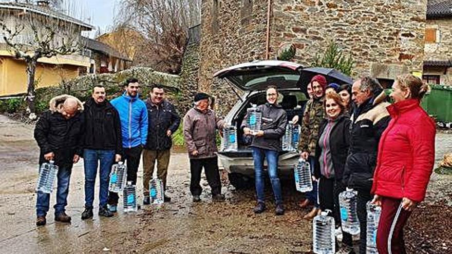 Vecinos de Riomanzanas con las botellas abastecidas por la Diputación.