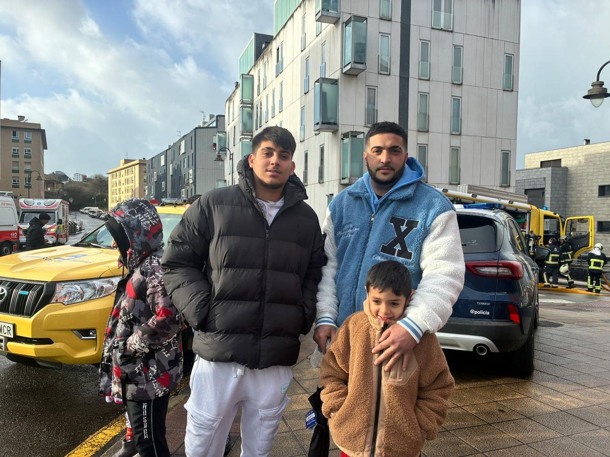 Isaac Jiménez con su hijo Isaac y su primo Antonio Jiménez, ayer, en la calle Balandro; al fondo, el edificio afectado.