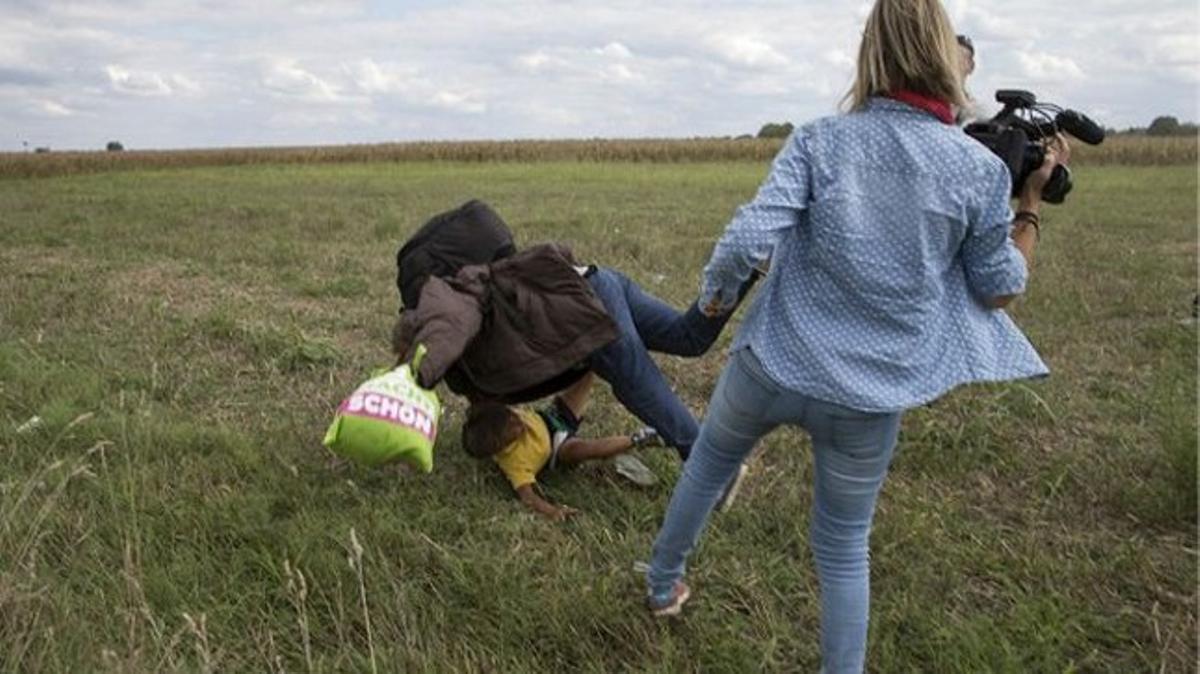 Diversos periodistes van gravar la reportera agredint els immigrants. En aquest cas, va tirar a terra un home amb un nen en braços. Diversos periodistes van gravar la reportera agredint els immigrants. En aquest cas, va tirar a terra un home amb un nen en braços.
