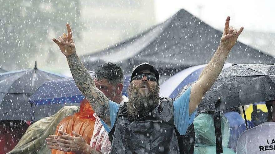 Un seguidor de Trump aguarda bajo la lluvia su llegada al acto previsto en Orlando (Florida). // Reuters