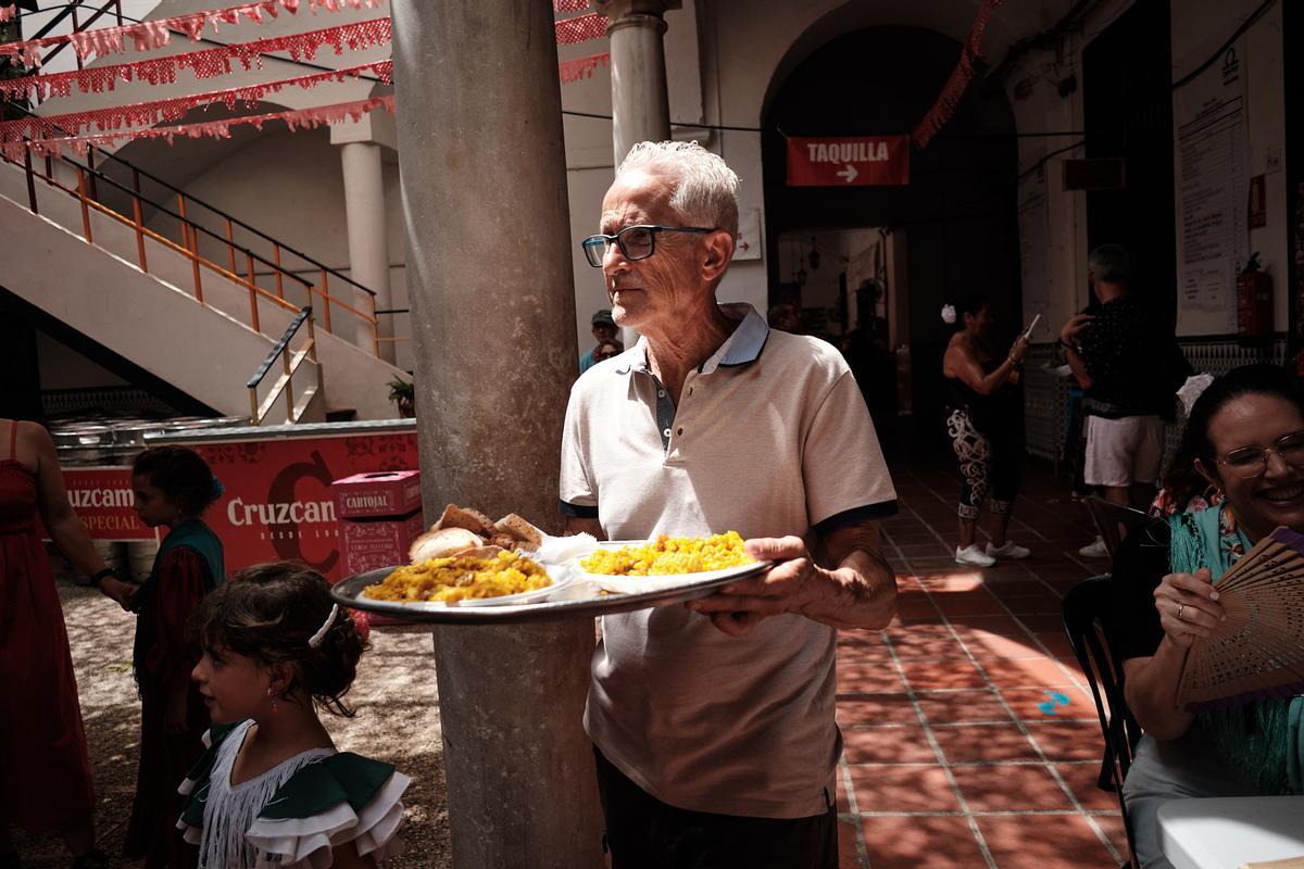 Un camarero sirviendo platos en una caseta de la Feria