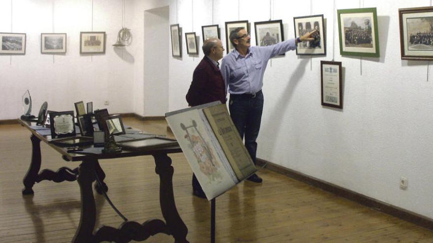 Luis González (izquierda) e Isidro Vergel identifican a algunos de los músicos que posan en una de las imágenes de la muestra. Foto