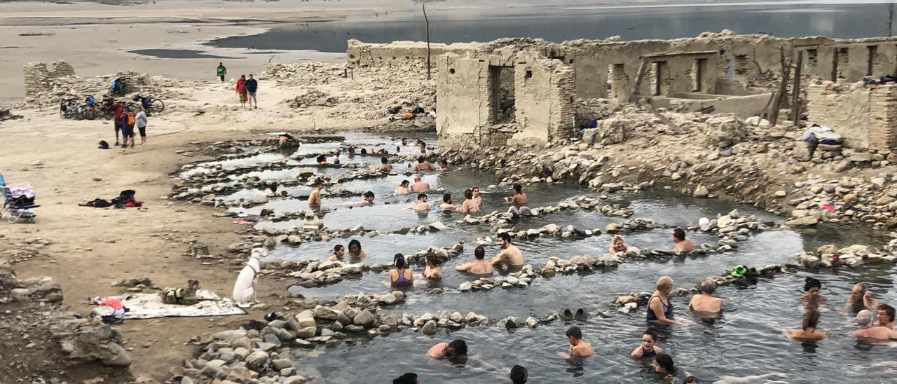 Decenas de bañistas en las antiguas termas romanas de Tiermas, al descubierto todavía por la sequía en el pantano de Yesa.