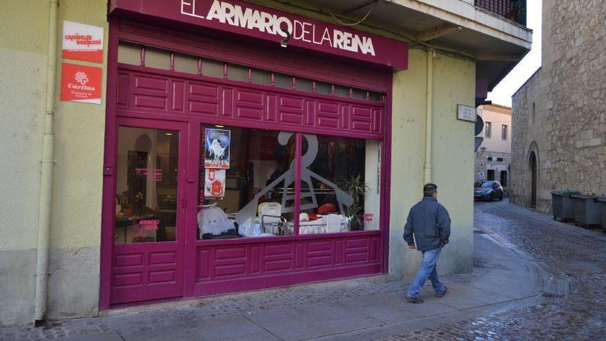 Un hombre pasa junto a la puerta de la tienda de ropa de segunda mano