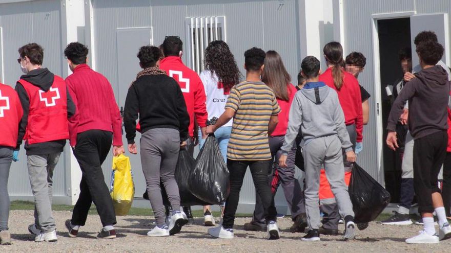 Varios menores extranjeros no acompañados, acompañados por voluntarios de la Cruz Roja.