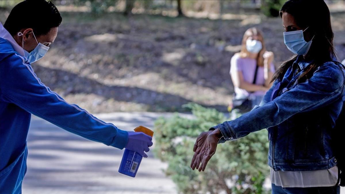 Un sanitario de Cruz Roja administra desinfectante a una mujer en Colmenar Viejo (Madrid) el 2 de septiembre del 2020