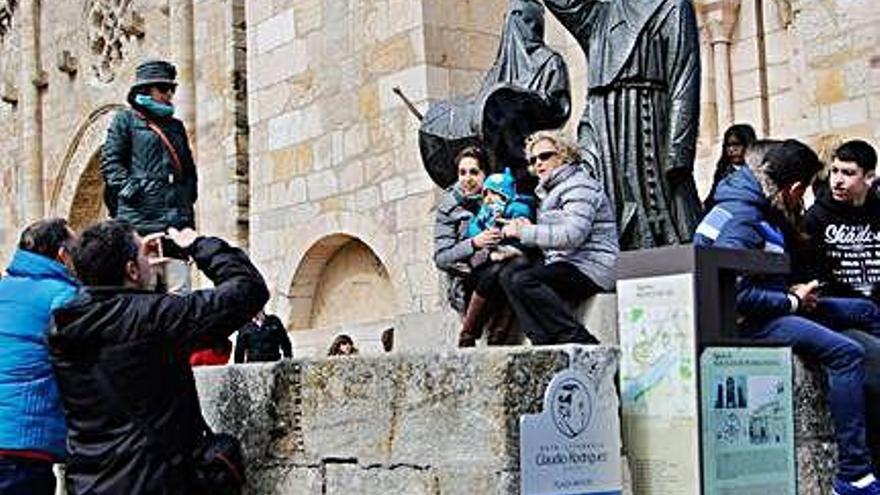 Turistas se hacen fotos junto a la escultura del Merlú.