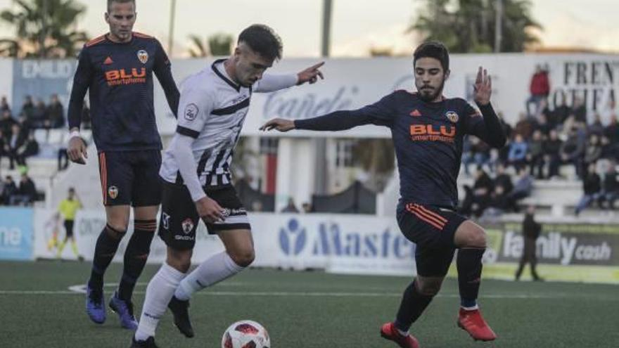 Un jugador del Ontinyent conduce el balón ante dos rivales del Valencia-Mestalla, en el partido.