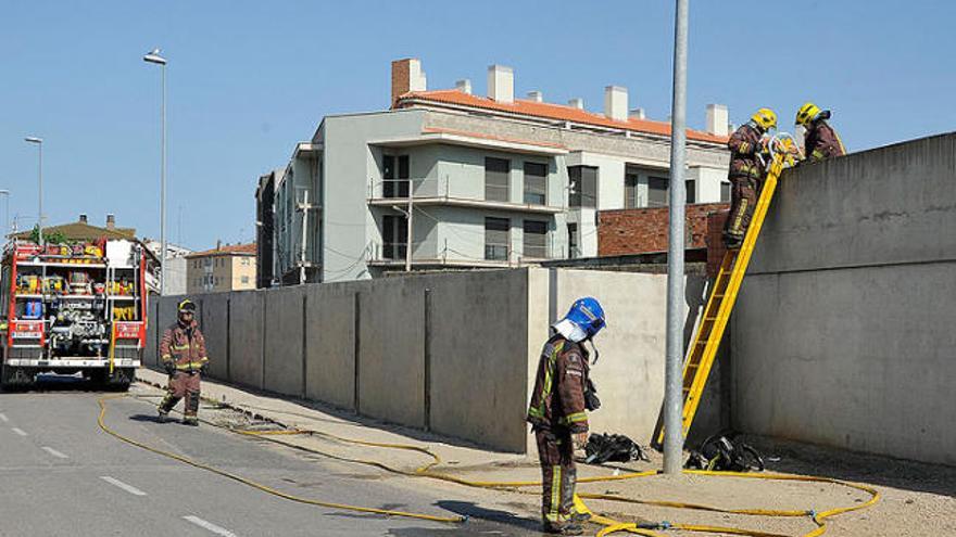 Els bombers remullant la zona on es va produir l&#039;incident, al barri de la Marca de l&#039;Ham.