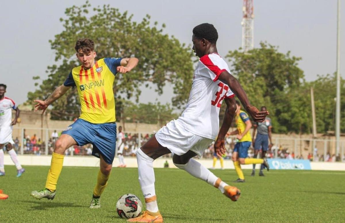 Un jugador del Ramassà con otro de un equipo gambiano.