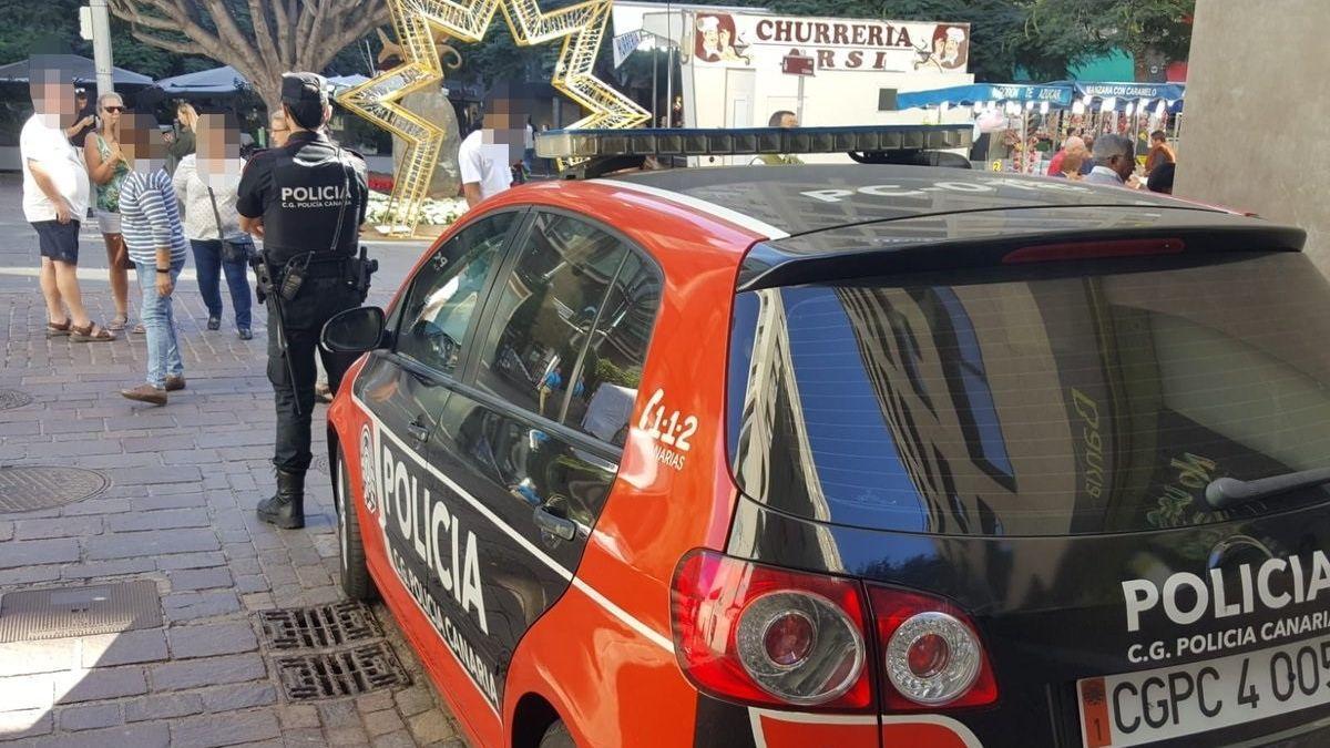 Agentes de la Policía Canaria junto a una patrulla.