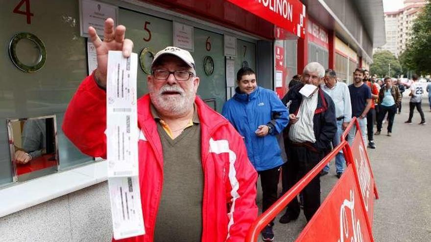 José Antonio Barroso, el primero de la fila, muestra sus entradas.