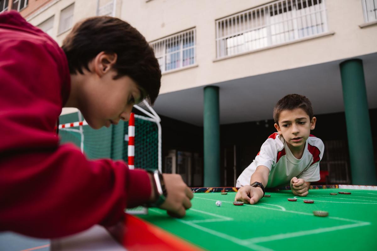 Niños juegan al fútbol chapa en el Colegio Claret de Madrid.