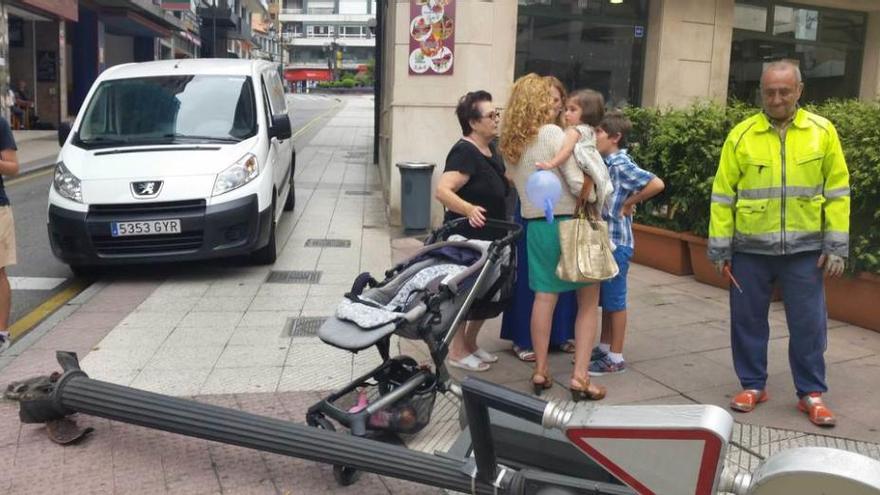 El semáforo derribado sobre el carrito de bebé, ayer, en la confluencia de Santa Clara y Foncalada, con la familia afectada detrás.