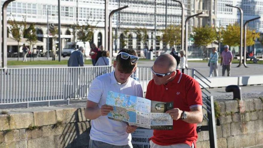 Dos turistas miran un mapa en su visita a la ciudad coruñesa.