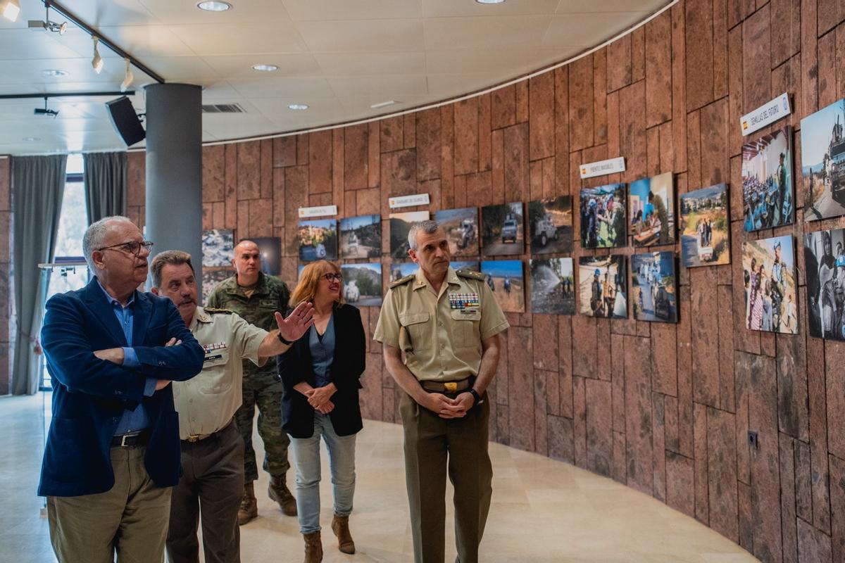 Casimiro Curbelo escucha las explicaciones de un mando militar en la sala de exposiciones.