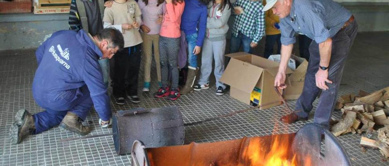 Ángel García, de pie a la derecha, con el bombo de castañas, ante la mirada de los escolares.