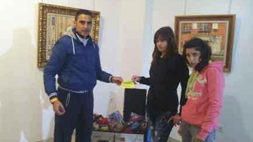 Óscar de Córdoba y las dos jóvenes afortunadas, durante la entrega de la cesta.