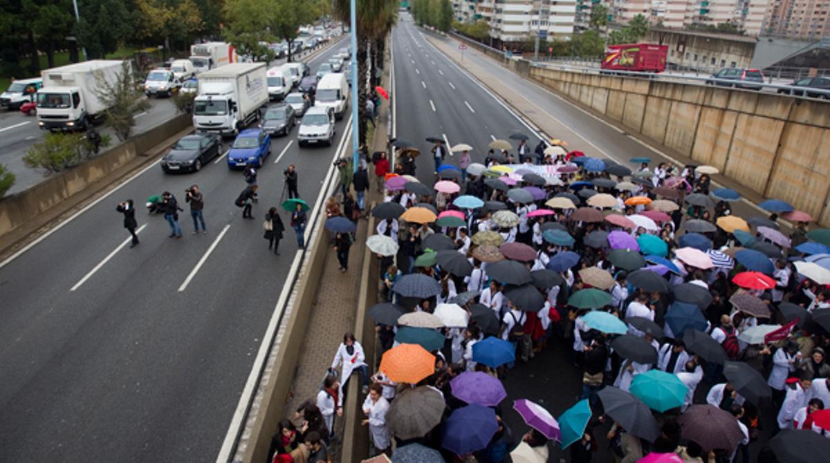 Centenars de persones han tallat la Ronda de Dalt durant uns 15 minuts i han provocat retencions quilomètriques per protestar contra les retallades en la sanitat pública catalana.