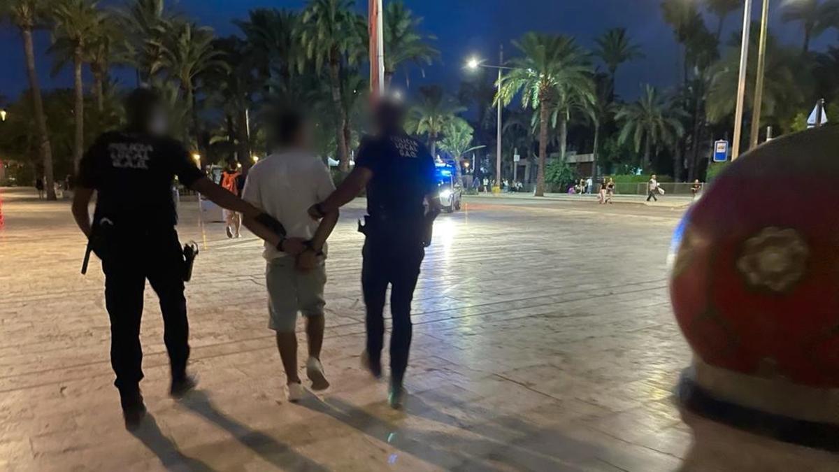 Dos policías trasladan al detenido por la agresión con arma blanca en als Fiestas de Elche