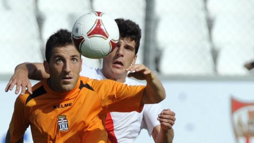 Óscar Rico controla el balón ante la oposición de un jugador del equipo sevillista.
