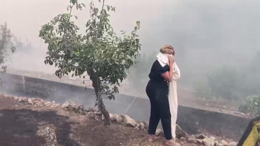 Una vecina en Boborás se protege del intenso humo.