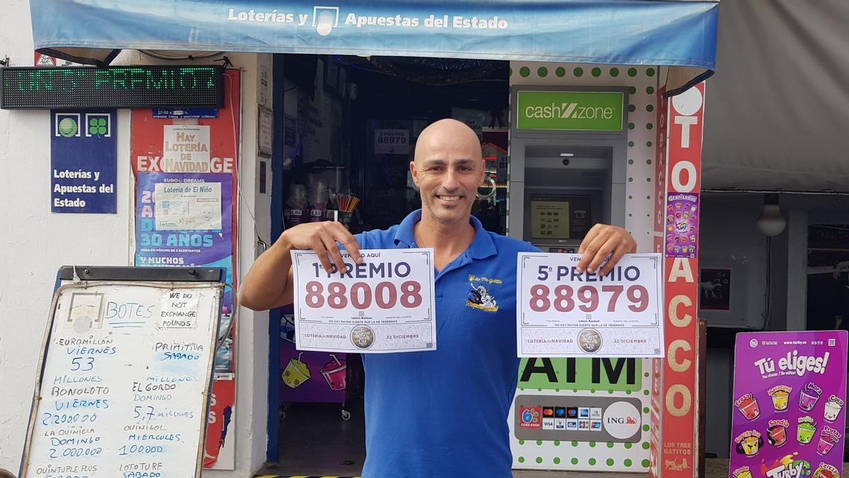 Jonathan Torres, responsable del despacho mixto Los Tres Gatitos, en el Centro Comercial Costa Luz de Puerto del Carmen, con los carteles del Gordo  y un quinto premio.