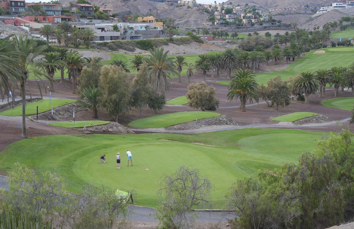 Tres personas jugando en el campo de Salobre Golf.